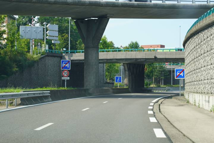 Voie rapide passant sous un pont, panneau de fin de route à accès réglementé