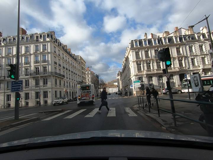 Carrefour en ville, un piéton traverse sur le passage piéton au feu vert