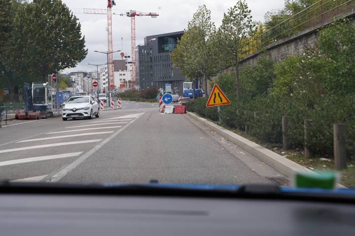Rue urbaine avec un panneau triangulaire de rétrécissement de chaussée à droite
