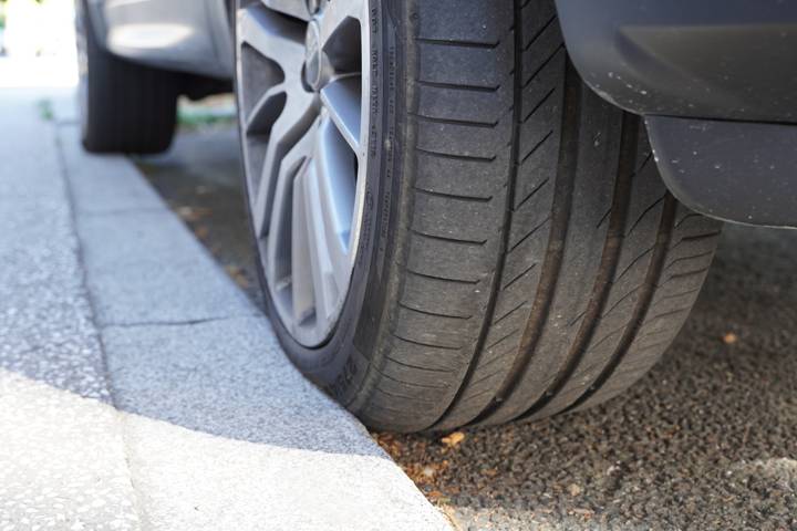 Gros plan d'un pneu de voiture qui frotte contre la bordure du trottoir