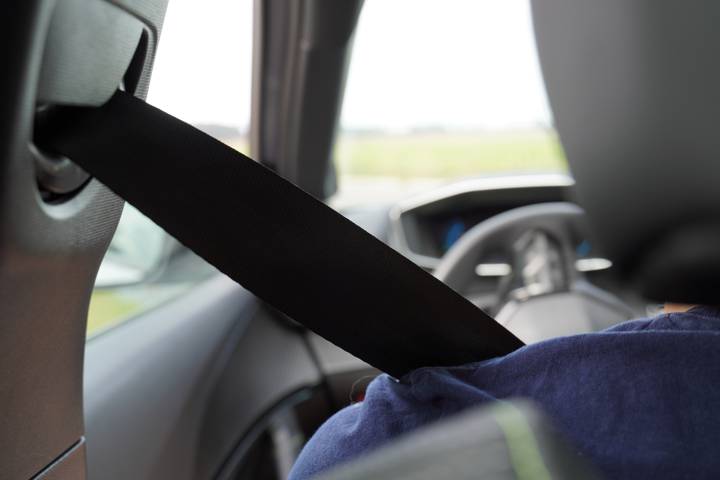 Intérieur d'un véhicule, ceinture de sécurité attachée sur un occupant