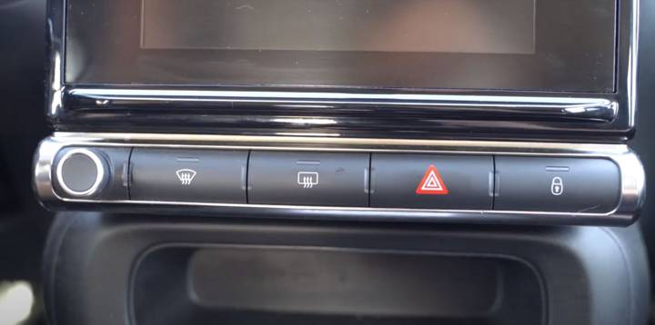 Console centrale du véhicule avec le bouton triangulaire rouge des feux de détresse