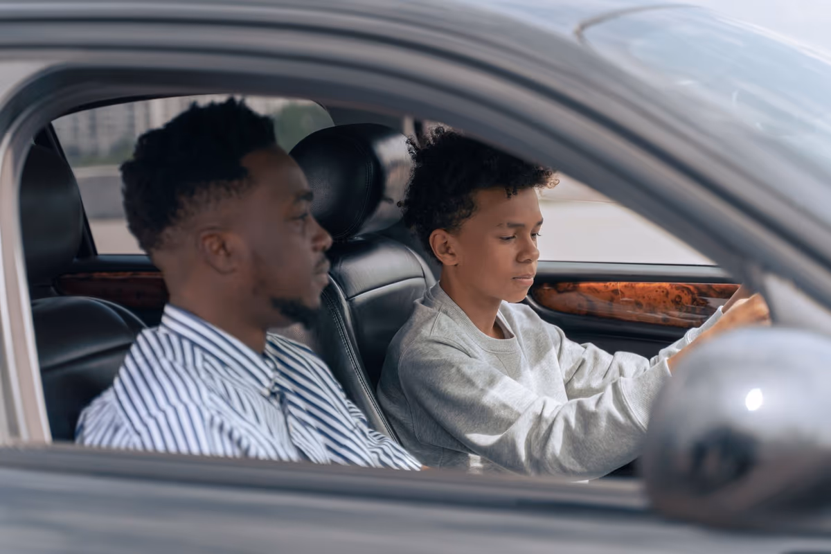 Un parent accompagne son enfant au volant pendant la conduite accompagnée